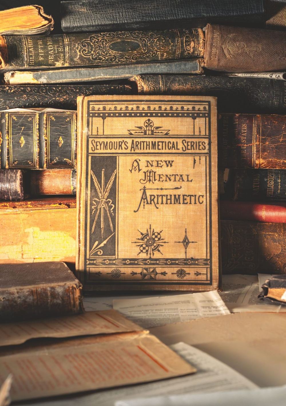 An antique arithmetic book among old leather bound volumes